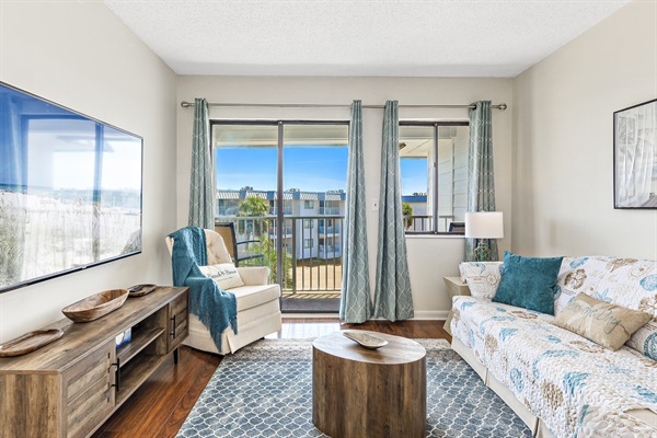Comfortable living room with 65" smart TV and sleeper sofa.