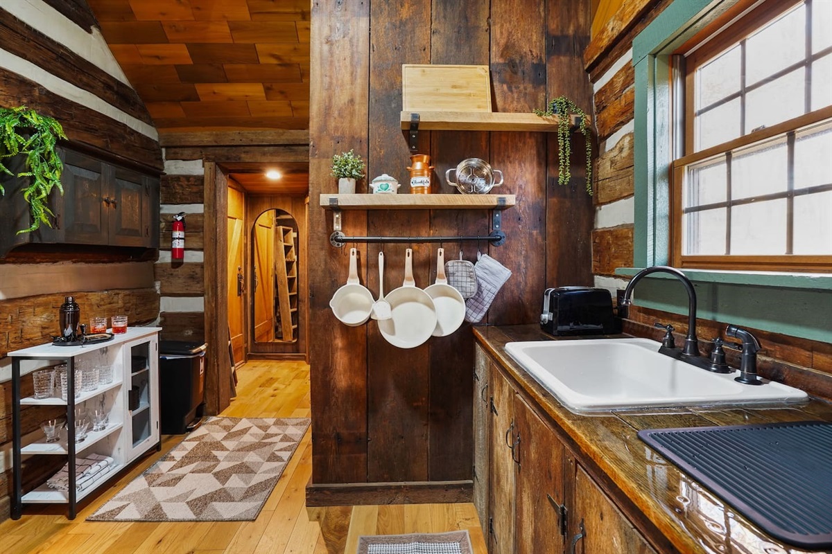 kitchen filled with pots, pans, dinnerware, and glassware - all you need for that perfect dinner date! 