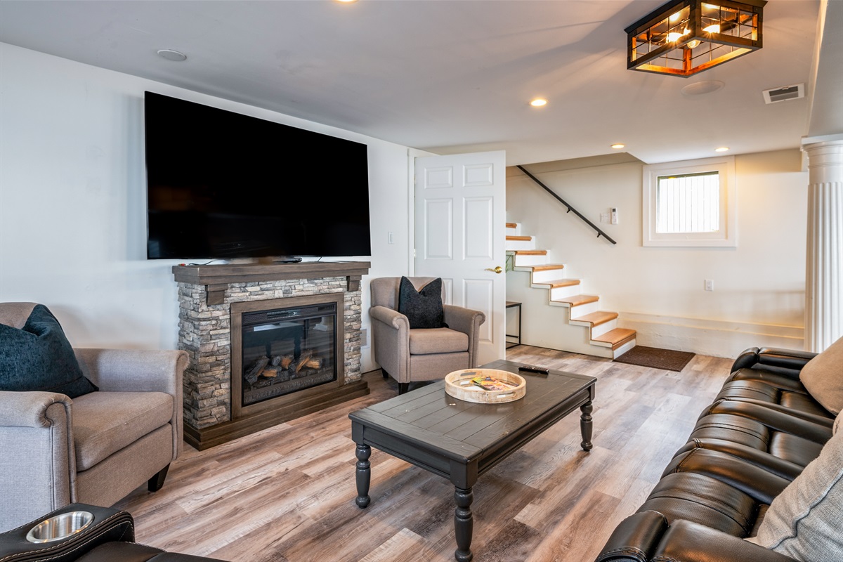 Kick back in this inviting living room with leather recliners, a stone fireplace, and big-screen TV 🔥🎬🛋️