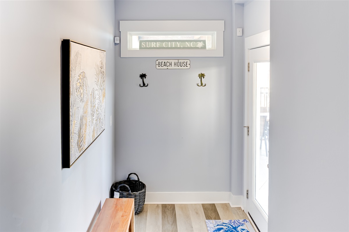 Bright entry area with coastal details, hooks for easy drop-off, and direct access to outdoor space