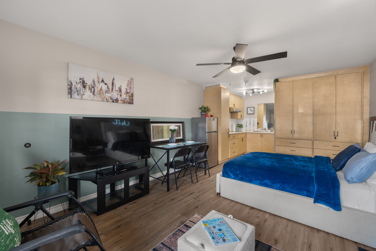 Studio view with the bed, TV, dining spot, kitchenette, and storage all in one easy space.
