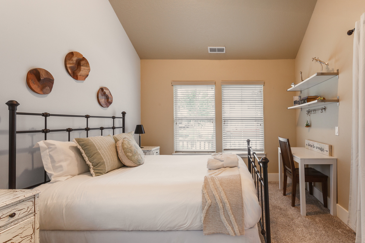 This bedroom has a queen bed and is located on the first floor, featuring a small workspace. It is bright and cozy!