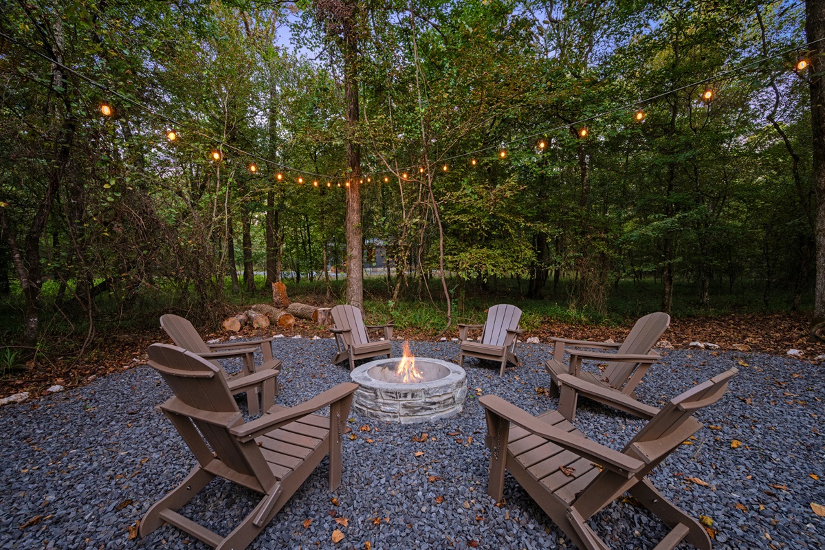 The fire pit seating area offers plenty of room for everyone to relax, roast marshmallows, and enjoy time together under the trees.