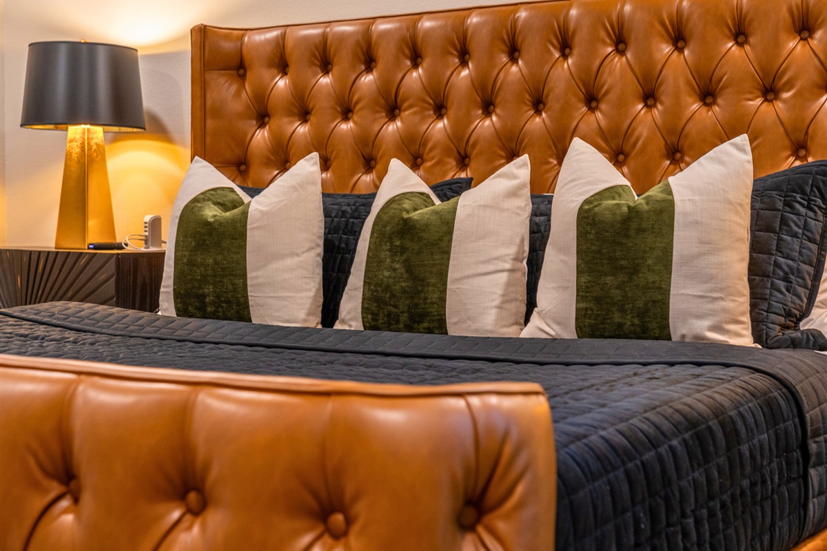 Soft, ambient lighting from chic bedside lamps enhances the room's warm and inviting atmosphere.