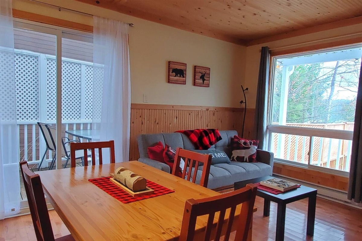 Dining room seating and living room with doors out to BBQ deck