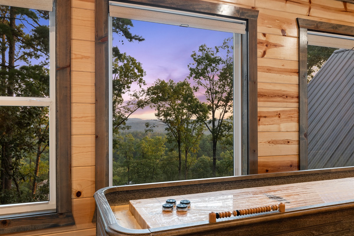 Scenic shuffleboard setup with breathtaking sunset and forest views