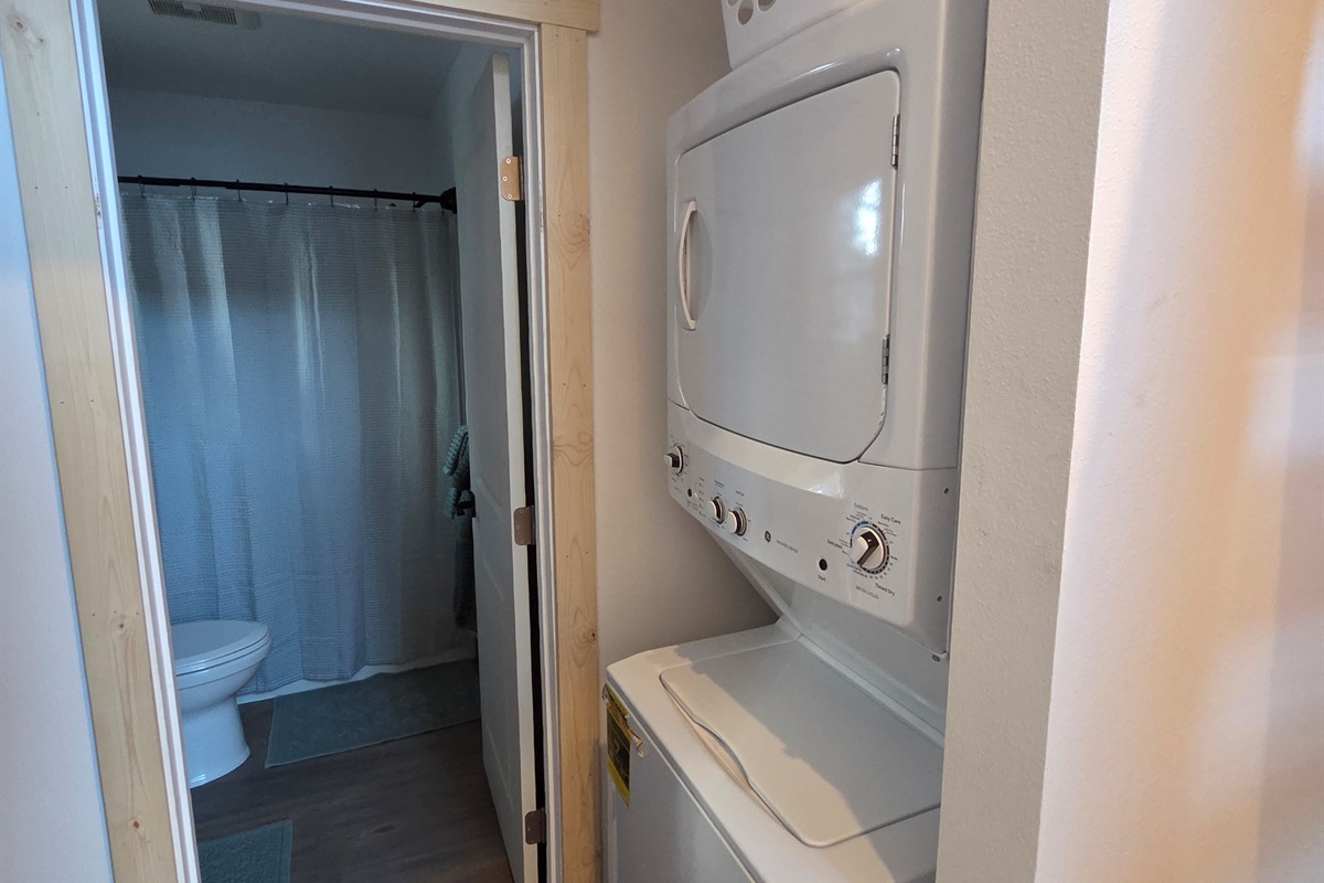 Laundry room with stacked washer / dryer located just outside bathroom [Photo is representative but is not from this cabin].