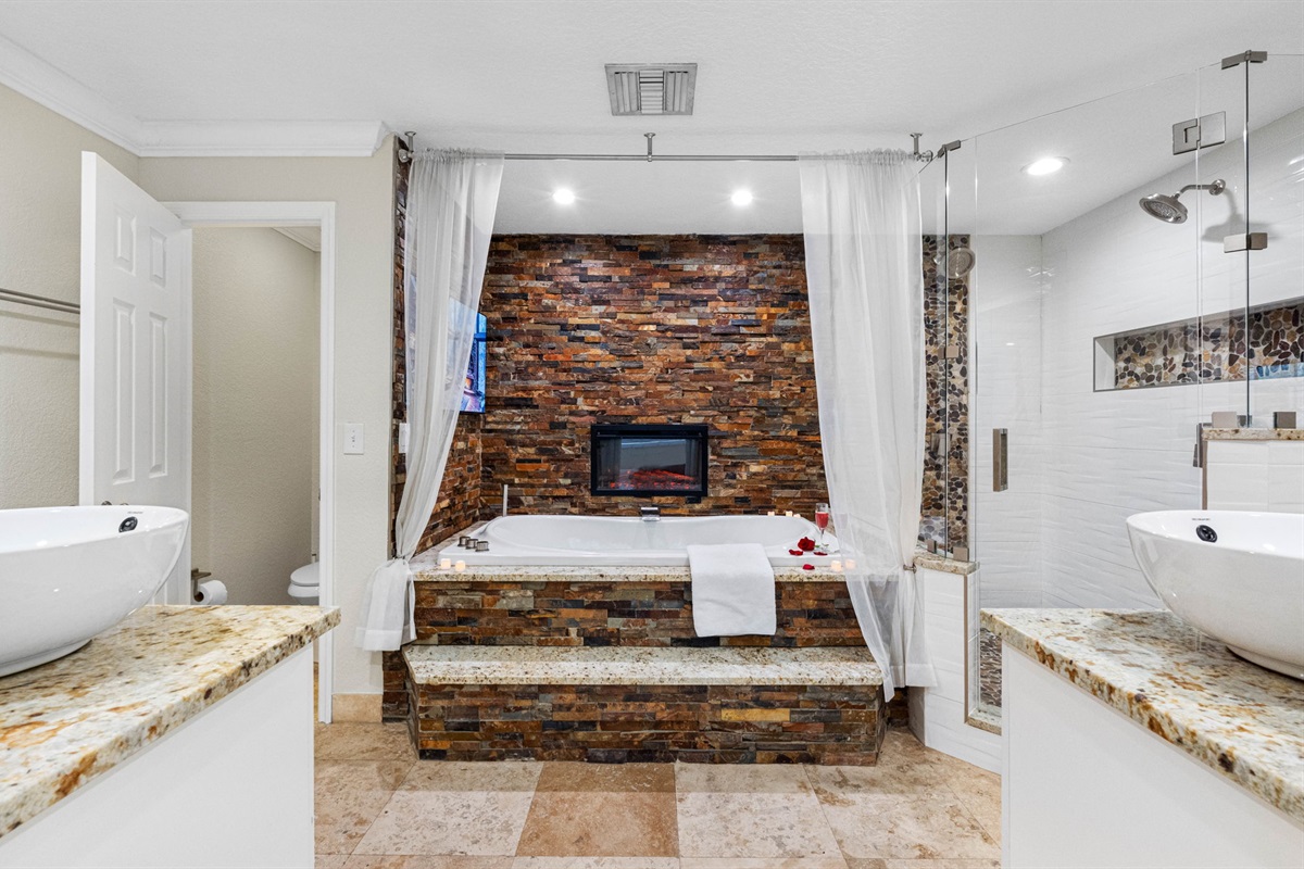 Just steps away, a separate glass-enclosed walk-in shower offers a refreshing alternative for a quick rinse.