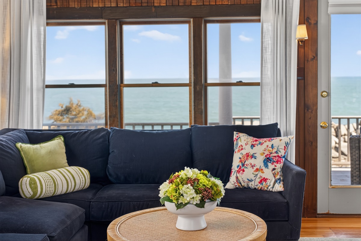 Relax in a bright, cozy living room with beautiful ocean views and coastal charm. 🌊