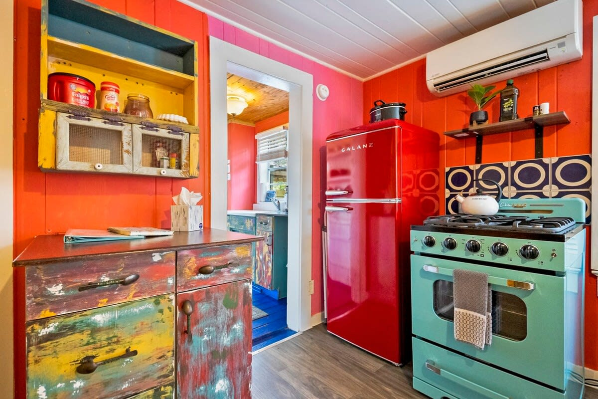 The retro fridge in tomato red and the seafoam range are the reason people remember this kitchen. The cooktop works beautifully for a proper dinner in, though the oven is decorative only and must not be used.