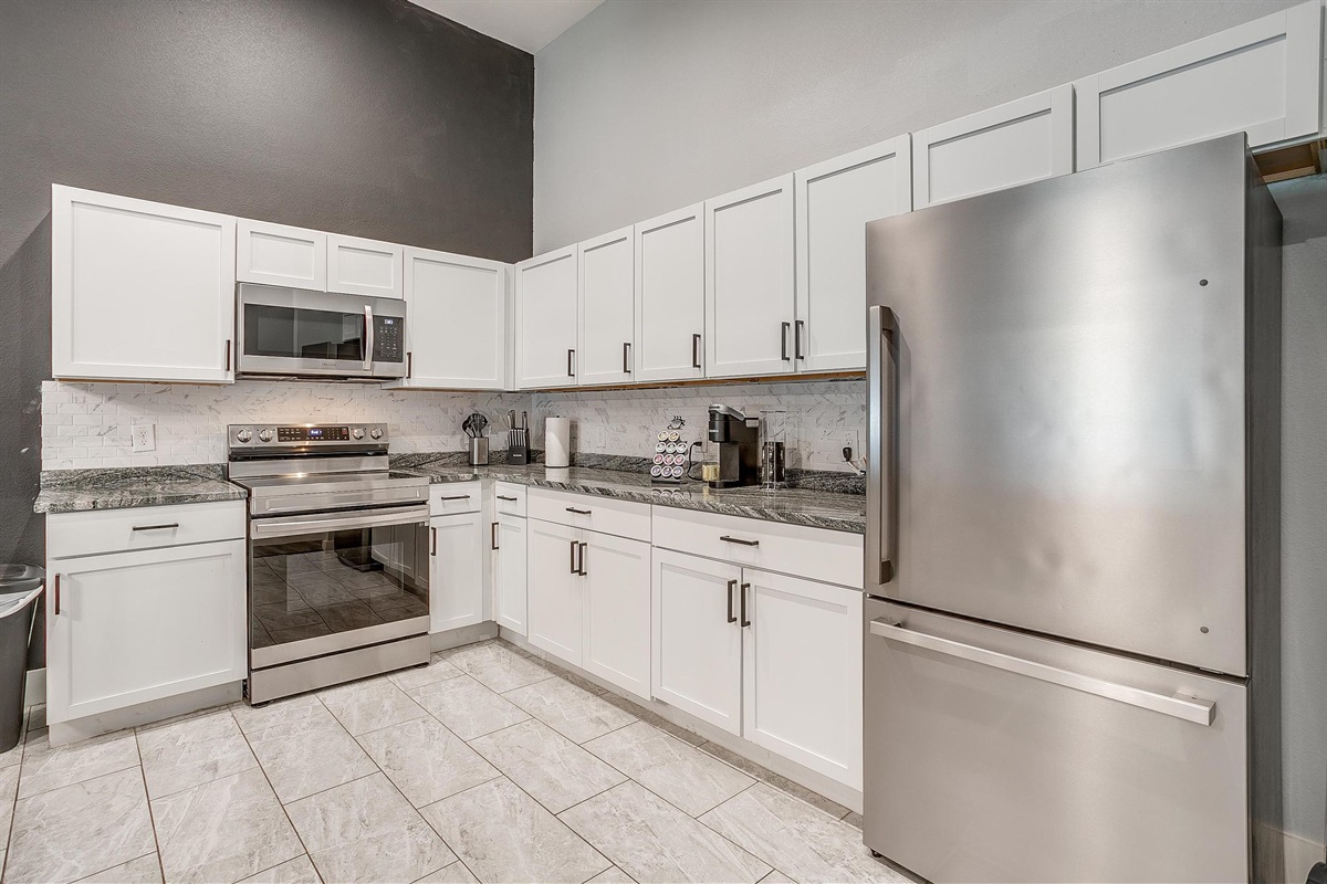 Fully stocked chef’s kitchen with stainless steel appliances.