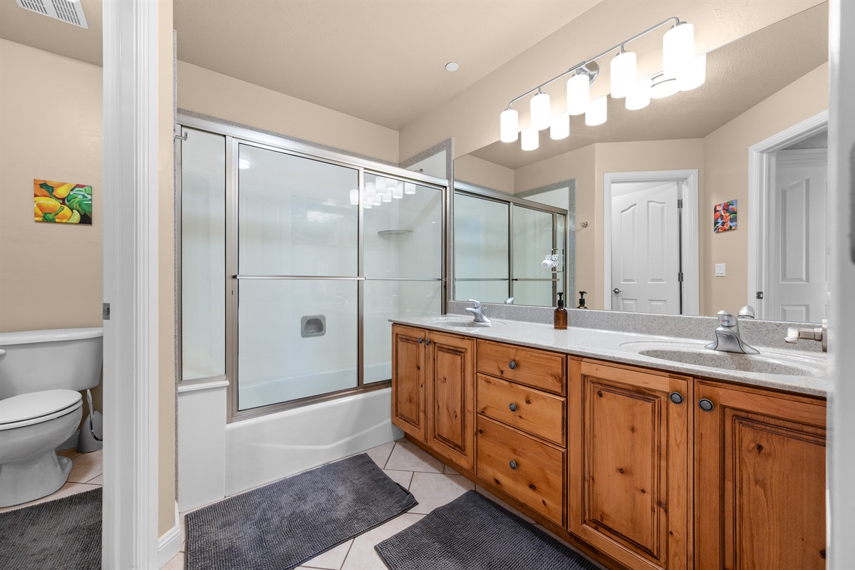 Full bathroom with double vanity and shower/tub combo—perfect for guests.