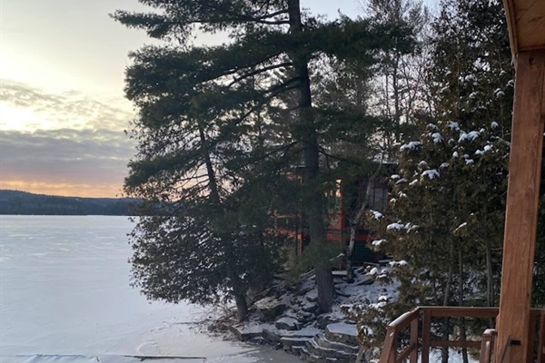 View across Lac McGregor to the west off hot tub deck area showing stairs leading to edge of lake and beach area