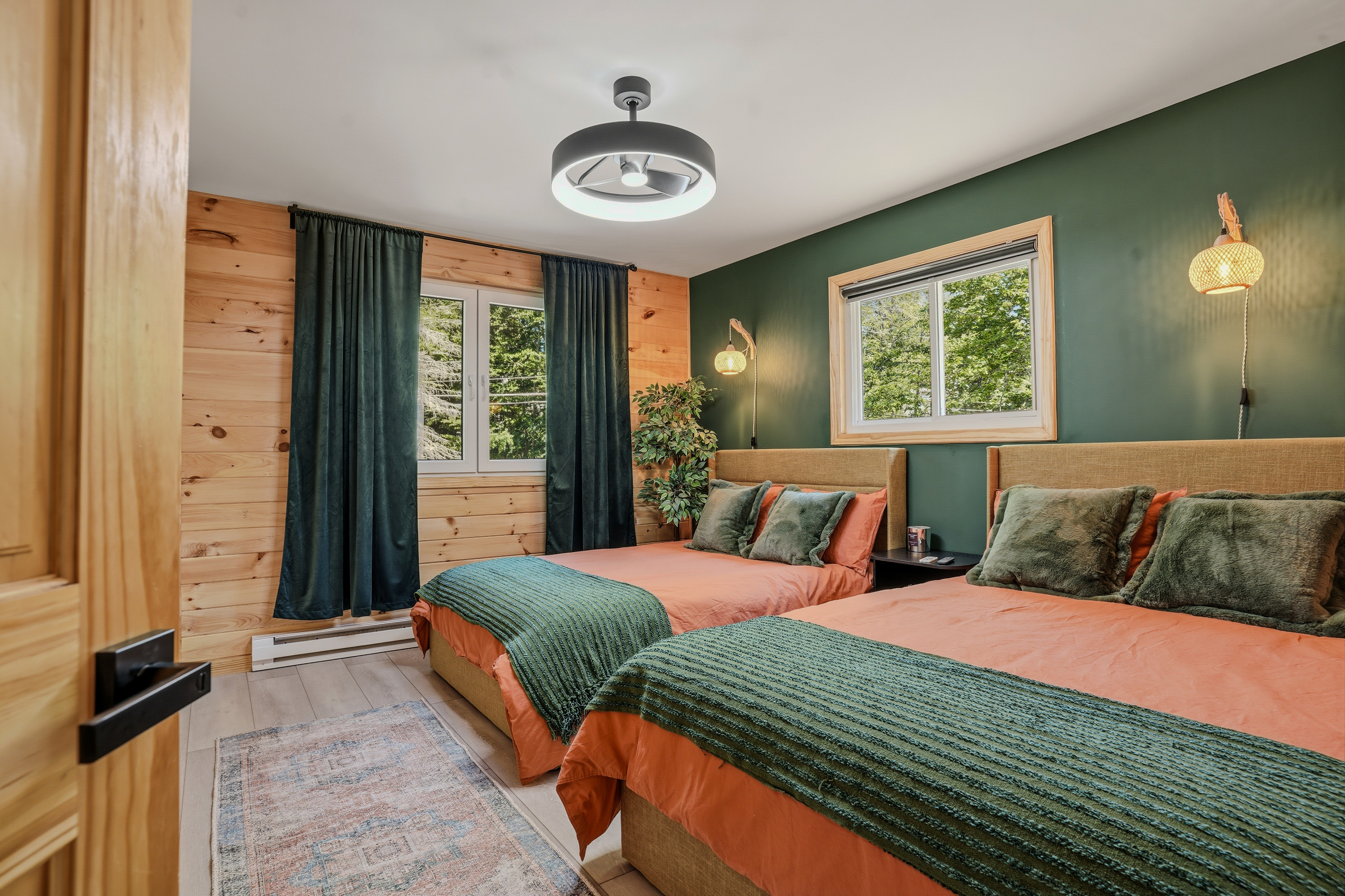 Fifth bedroom with two full beds, green walls, pendant lighting, and wood-panel detailing