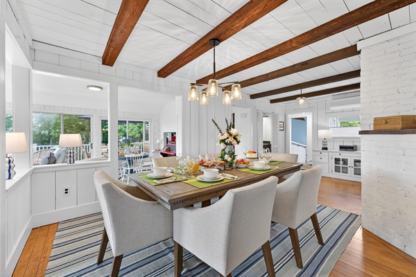 Bright dining area with a 6-seater table surrounded by beautiful natural light from large windows.