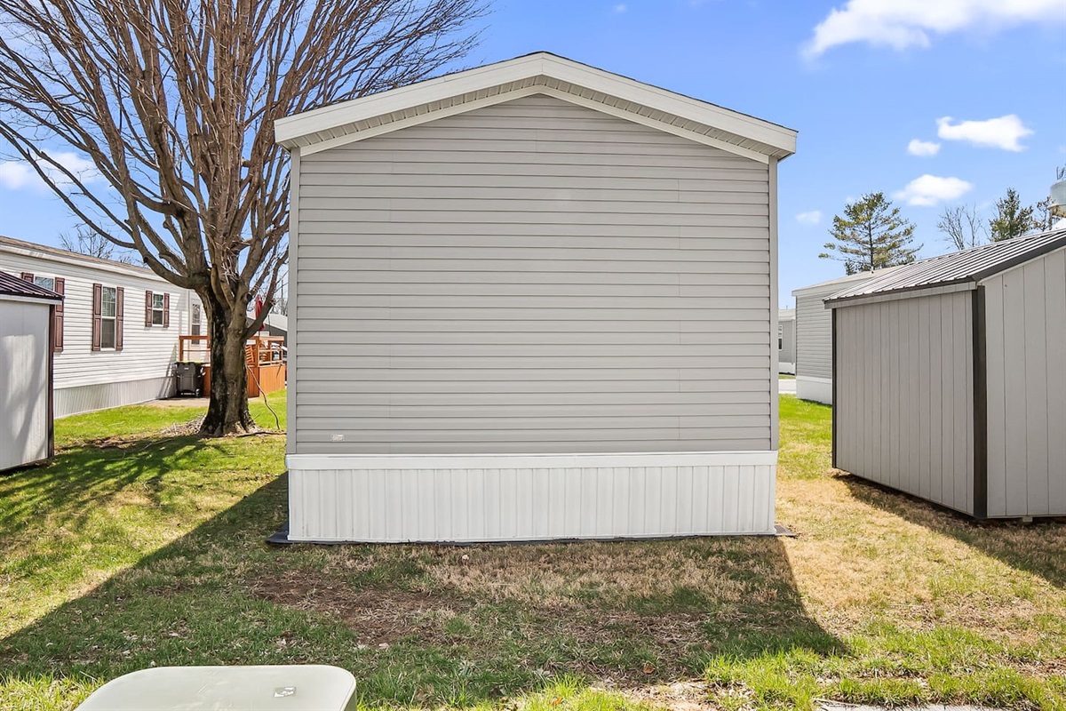 Rear exterior view showcasing a quiet setting with ample outdoor space and natural surroundings.
