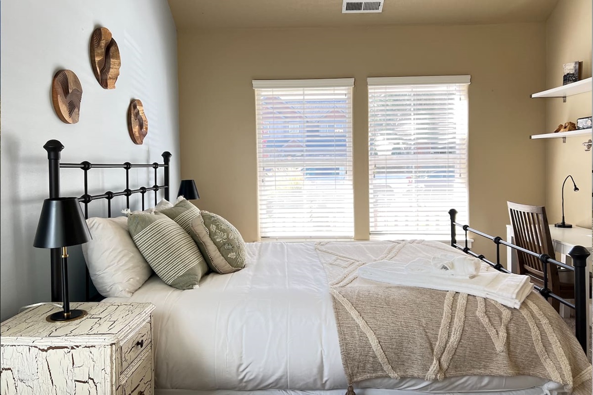 This bedroom has a queen bed and is located on the first floor, featuring a small workspace. It is bright and cozy!
