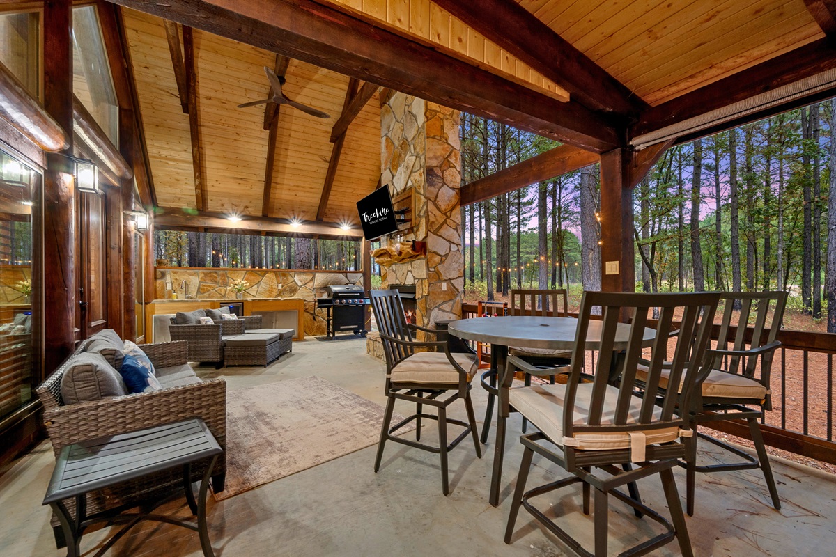 Outdoor living space with dining table, seating, and grill.