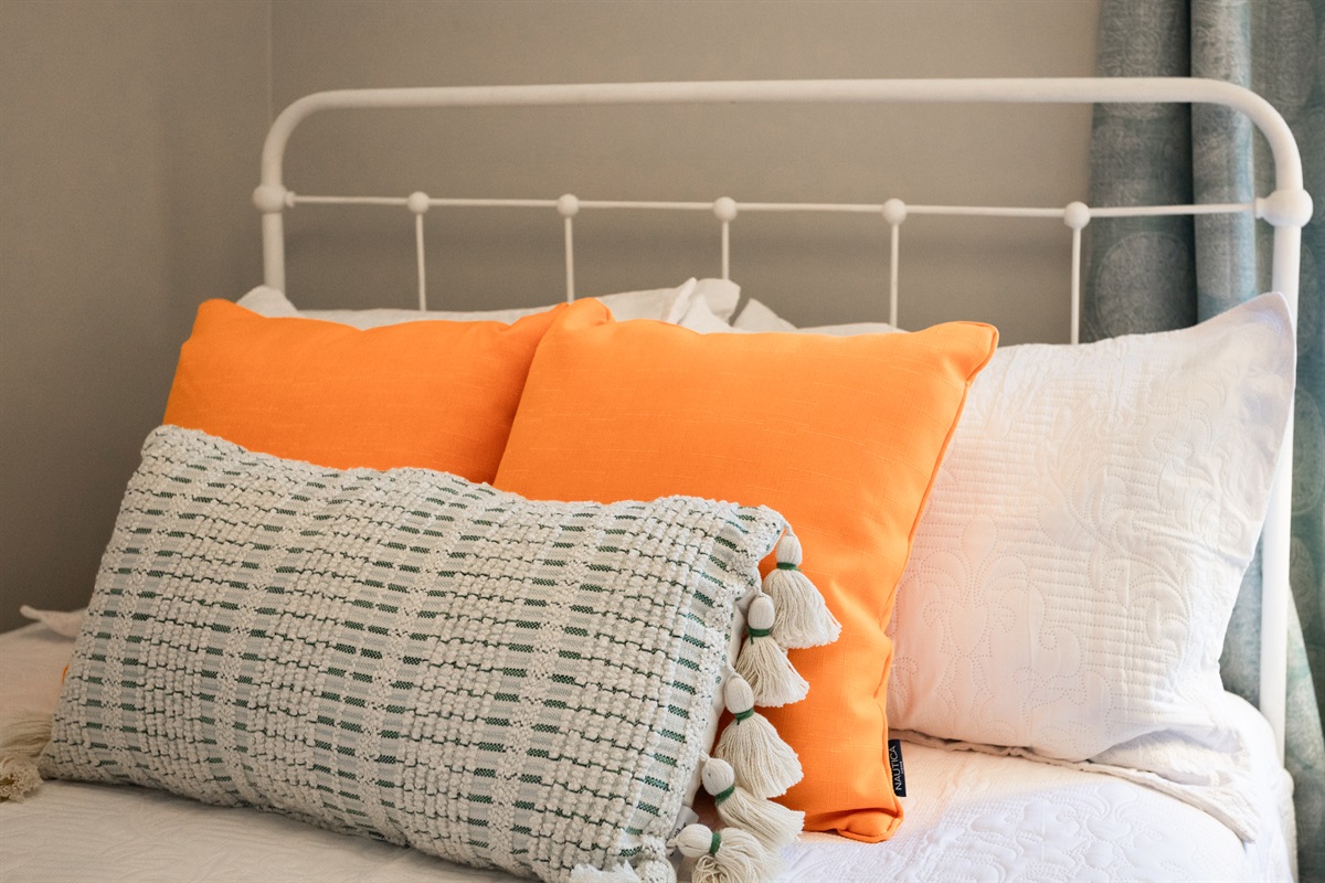 Fresh white linens and colorful accents create a welcoming retreat.
