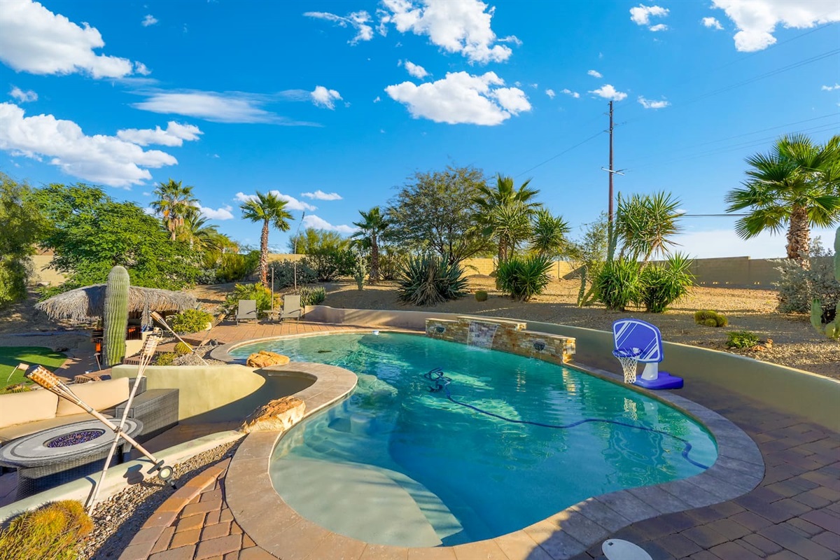 Spacious resort-style pool with a built-in basketball hoop, desert landscaping, and plenty of room to swim and play.