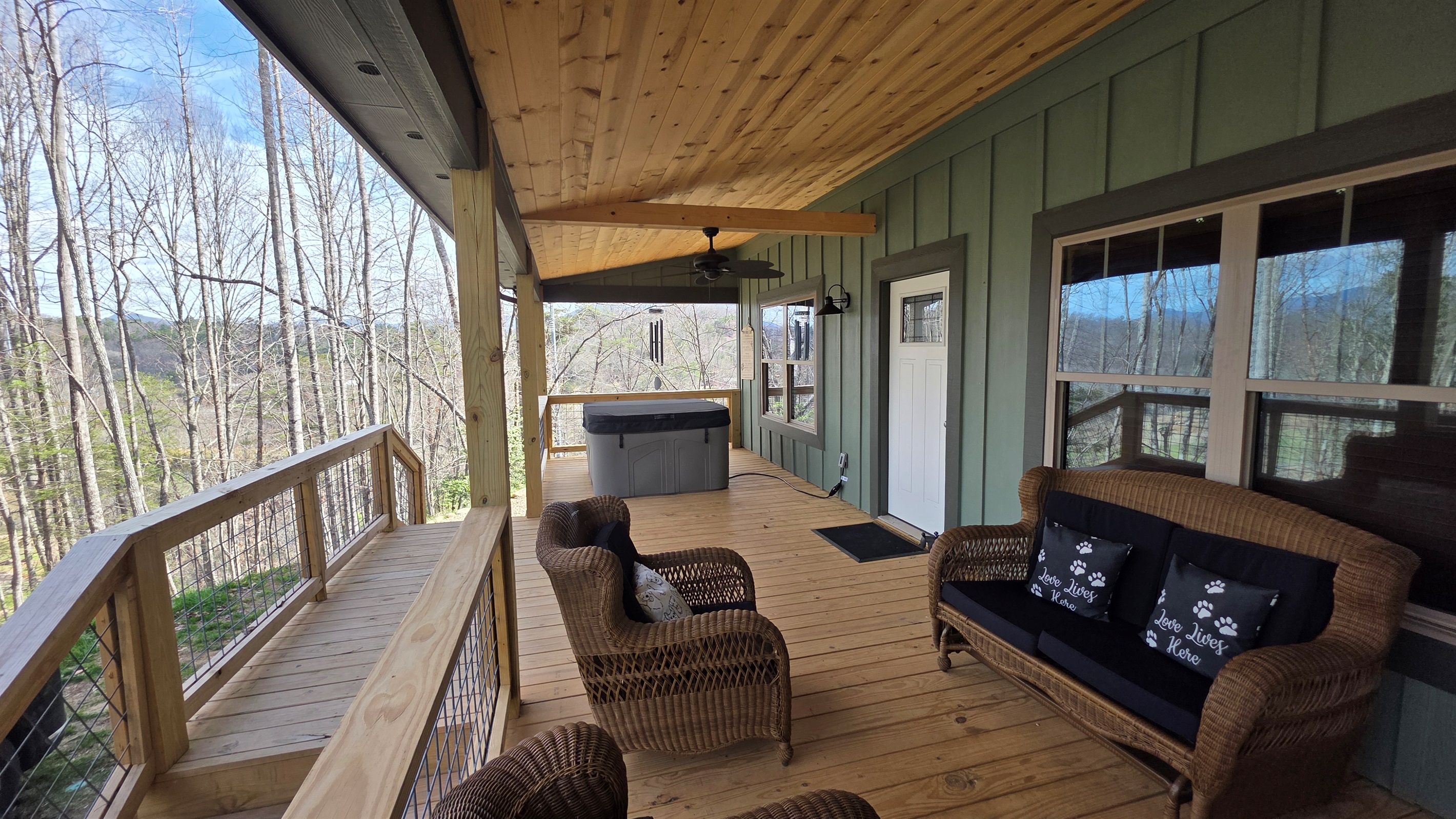 Large covered front porch with ceiling fans, private hot tub and rocking chairs.