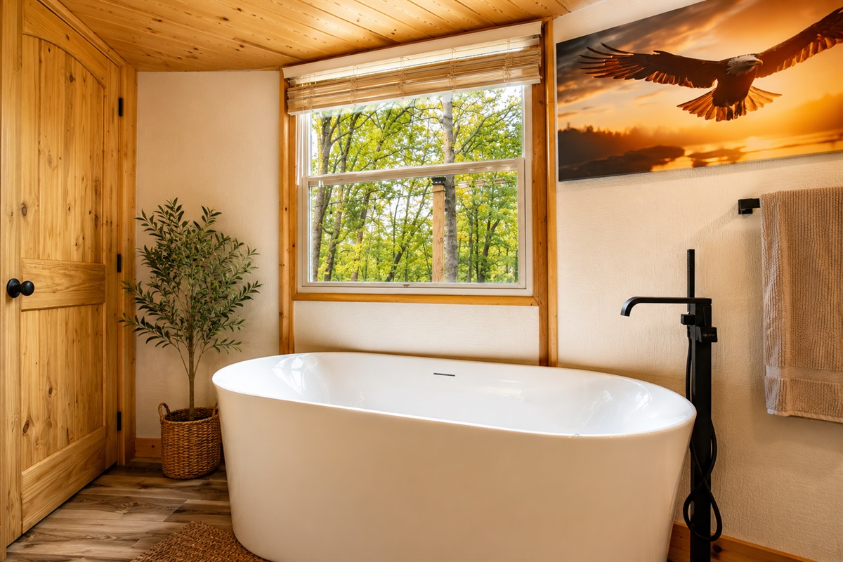 Soak in the tub with peaceful forest views — one of the most relaxing spots in the retreat