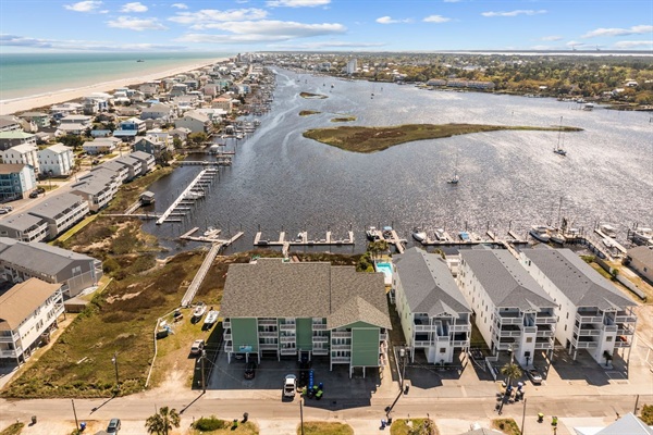 Property view with canal in front and beach to left.