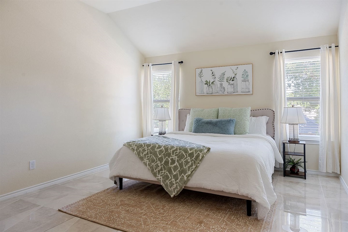 Enter a calm bedroom with a comfortable bed, chic bedside lights, and subtle wall art of botanicals.