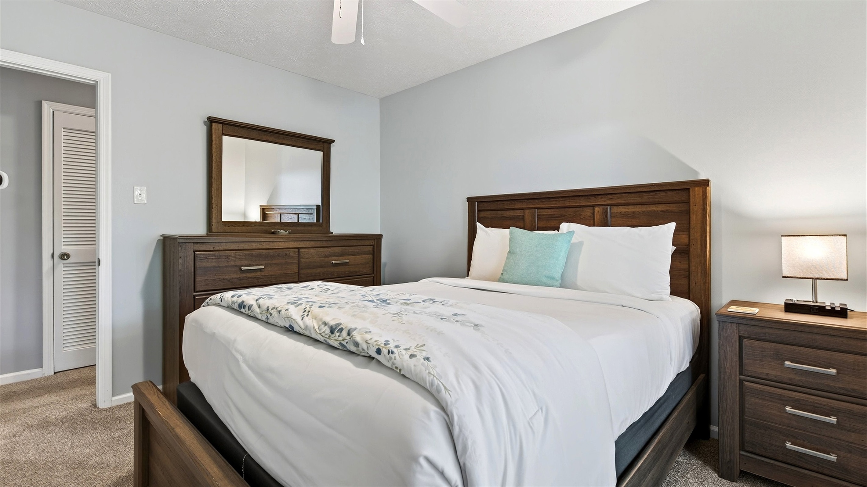 Main level bedroom 3 features a queen size bed.