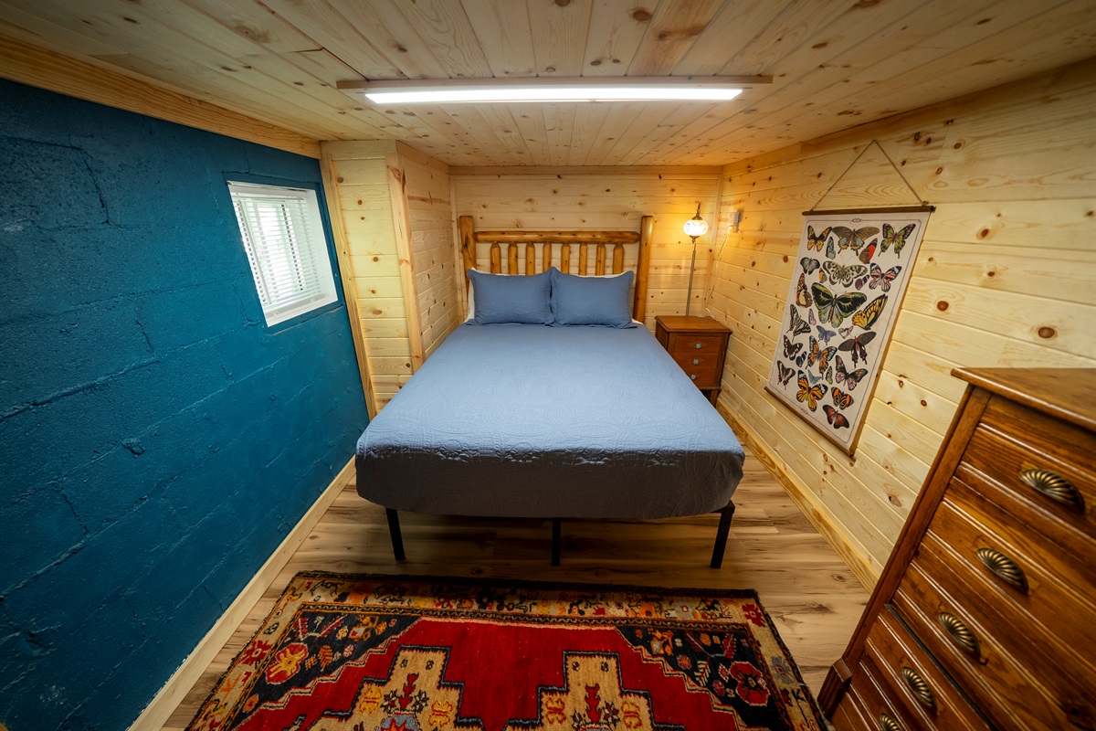 Cozy basement bedroom with queen bed and Smart TV, featuring approximately 6 ft ceilings