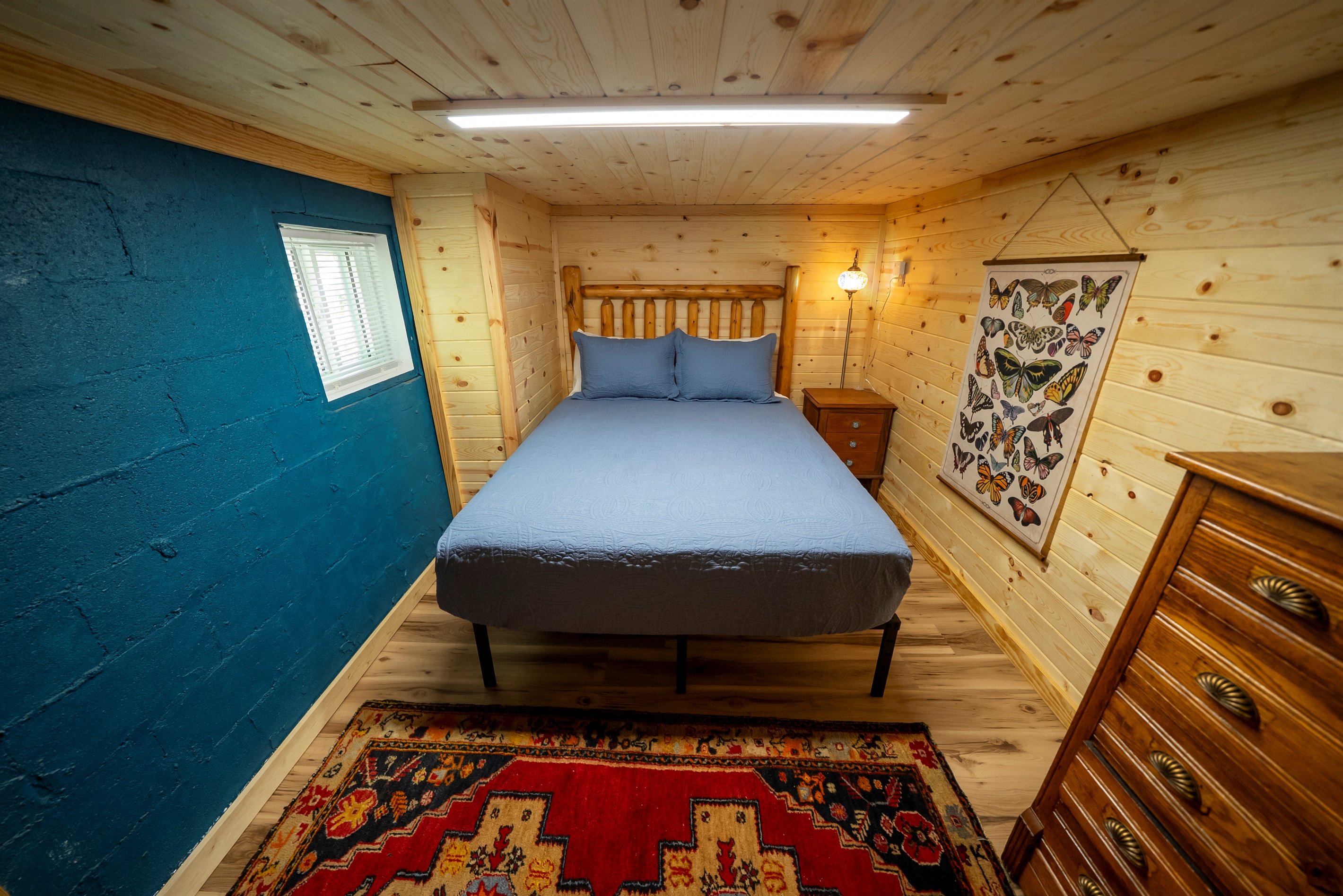 Cozy basement bedroom with queen bed and Smart TV, featuring approximately 6 ft ceilings