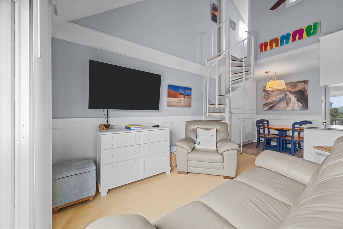 Soaring ceilings and a spiral staircase lead to the loft, giving this living space an open, coastal feel