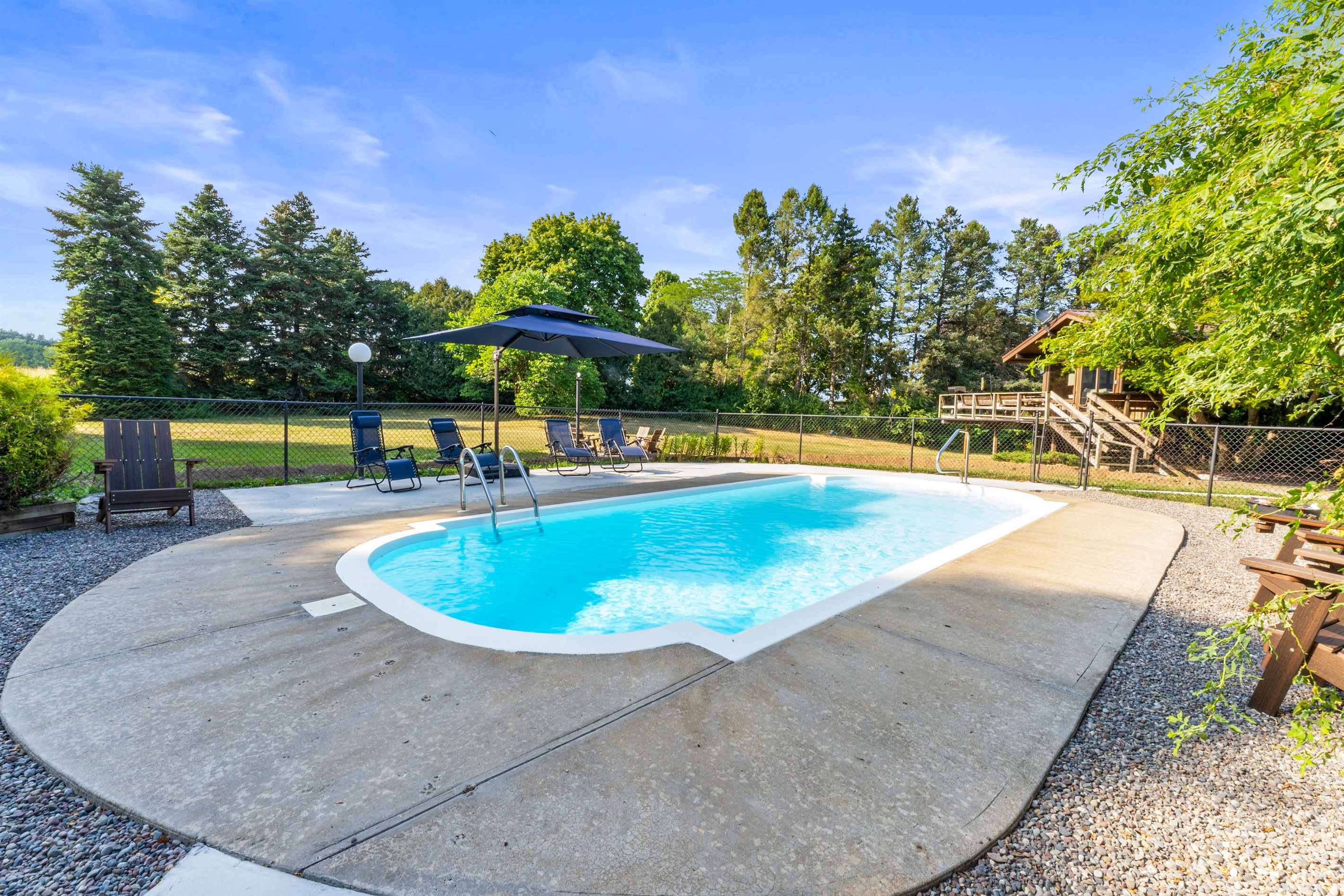 Relax and unwind by the sparkling private pool, surrounded by lush greenery and cozy seating for the perfect outdoor escape.
