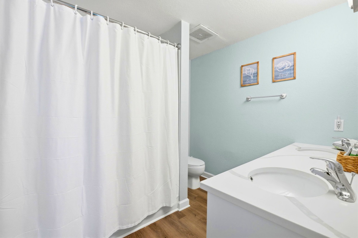 A full shower and tub setup makes this bathroom practical for both quick rinses and relaxing evenings.