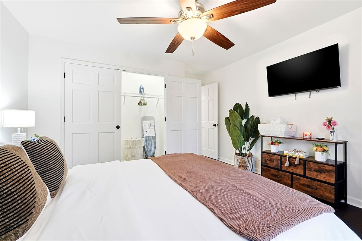 Upstairs bedroom located to the right, featuring a floral-inspired design and a comfortable double bed. Includes a smart TV and easy access to a shared bathroom. This room includes 2 full-body towels, 2 washcloths, and 2 hand towels for your stay.