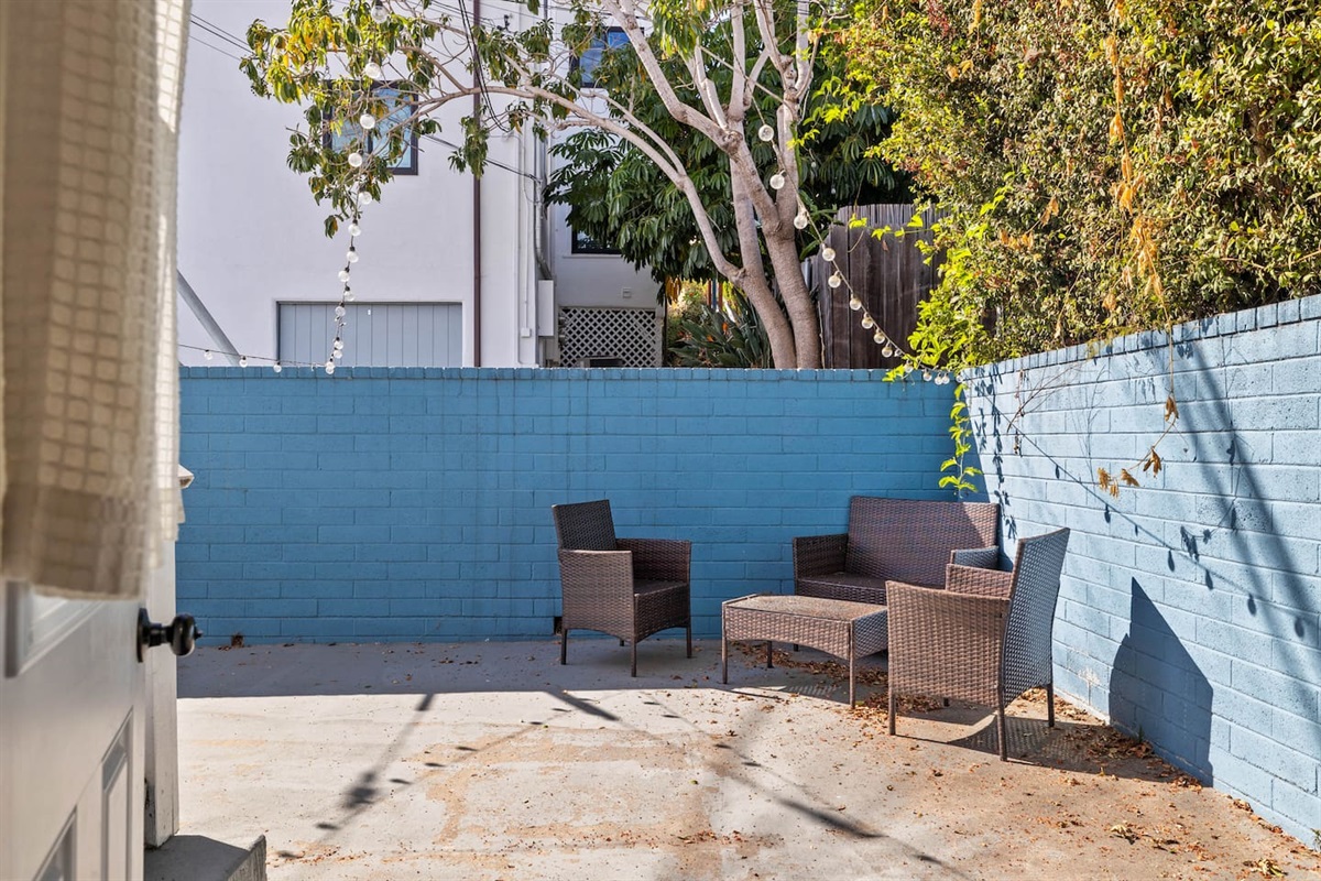 The exterior boasts a spacious outdoor area with a large wooden table and three smaller wooden tables, perfect for gatherings. Surrounded by natural beauty, this wide, open space invites you to relax and enjoy the fresh air.