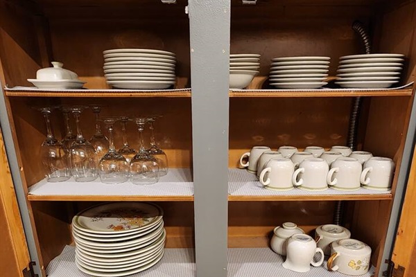 Wine glasses and additional dishes under the counter.