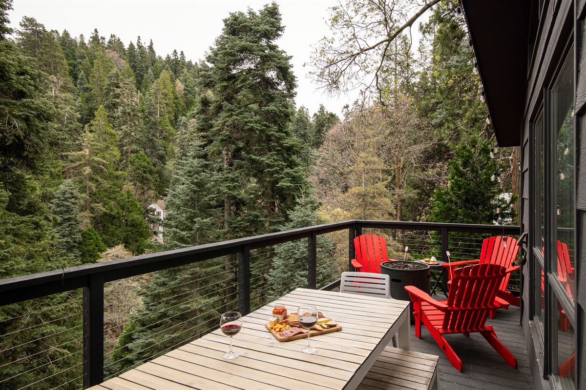 Scenic deck with outdoor dining, fire pit, and forest views—perfect for sunset drinks, relaxing evenings, and enjoying your Lake Arrowhead cabin getaway.