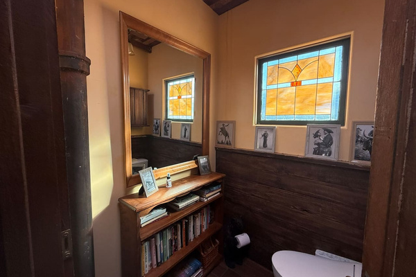 History, family and a little high-tech comfort meet in the first powder room: a Toto bidet toilet, reclaimed ranch-fence paneling stained-glass window, and lots of books to peruse should you want to linger. 