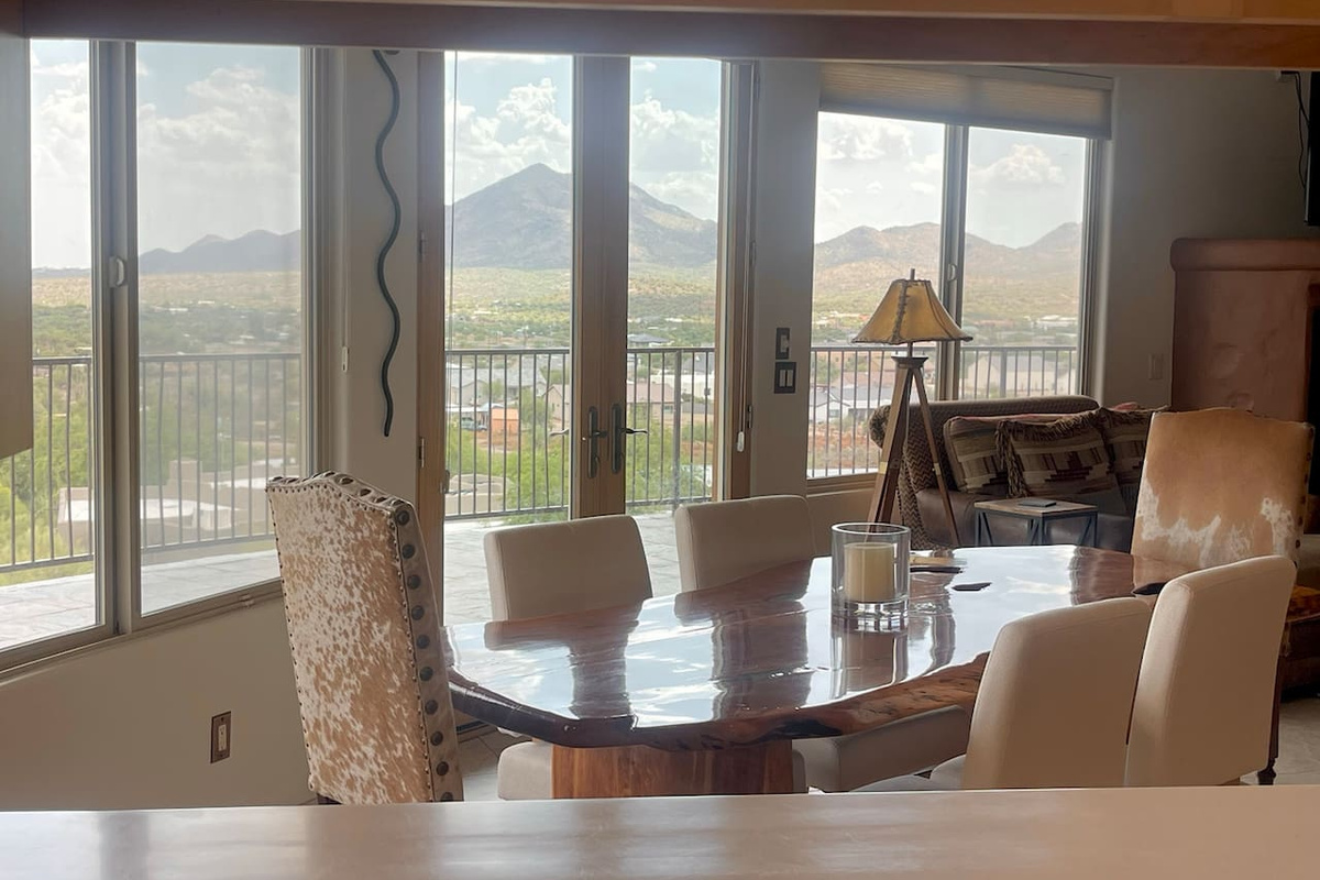 Gather around the table for meals, conversations, and time together, with natural light and mountain views just beyond the glass doors.