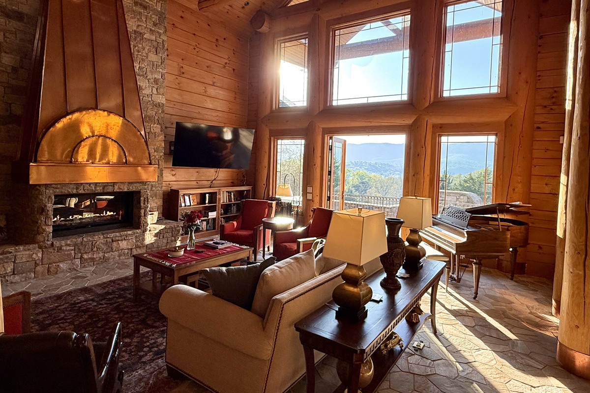 Bright, open living room with a large propane fireplace and stunning views throughout