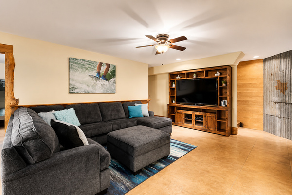 Cozy downstairs living area with a spacious sectional, large-screen TV, and plenty of room to relax together after a day on Lake Travis. A comfortable second gathering space for movie nights, games, or simply unwinding during your stay.