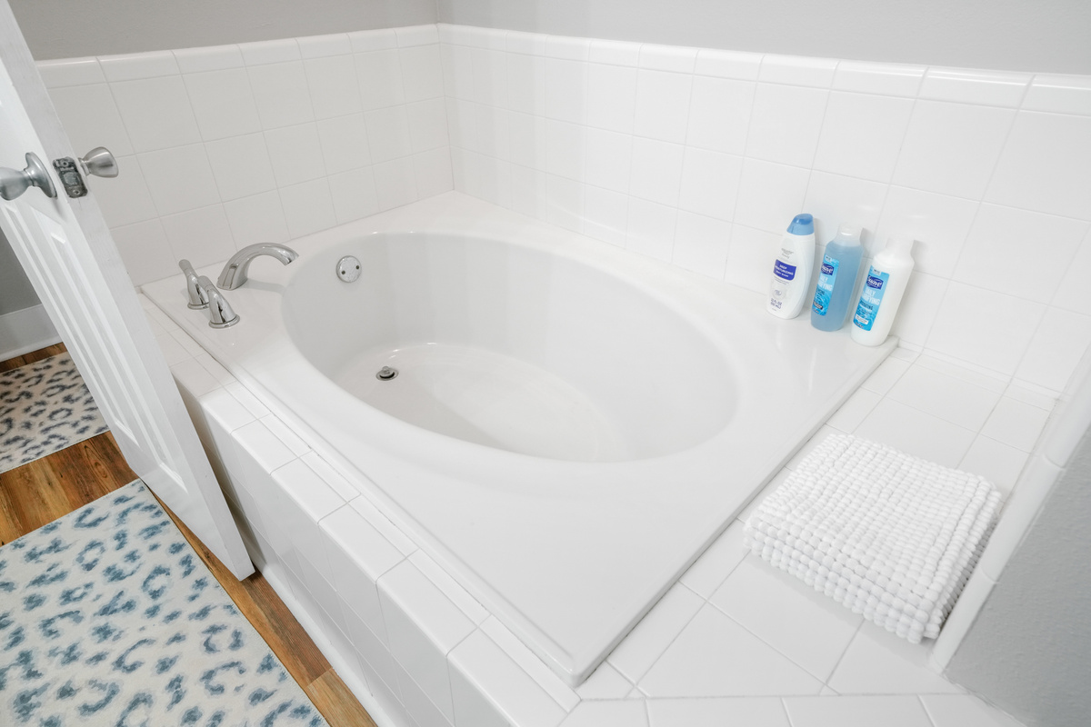 A deep soaking tub with fresh towels and starter toiletries