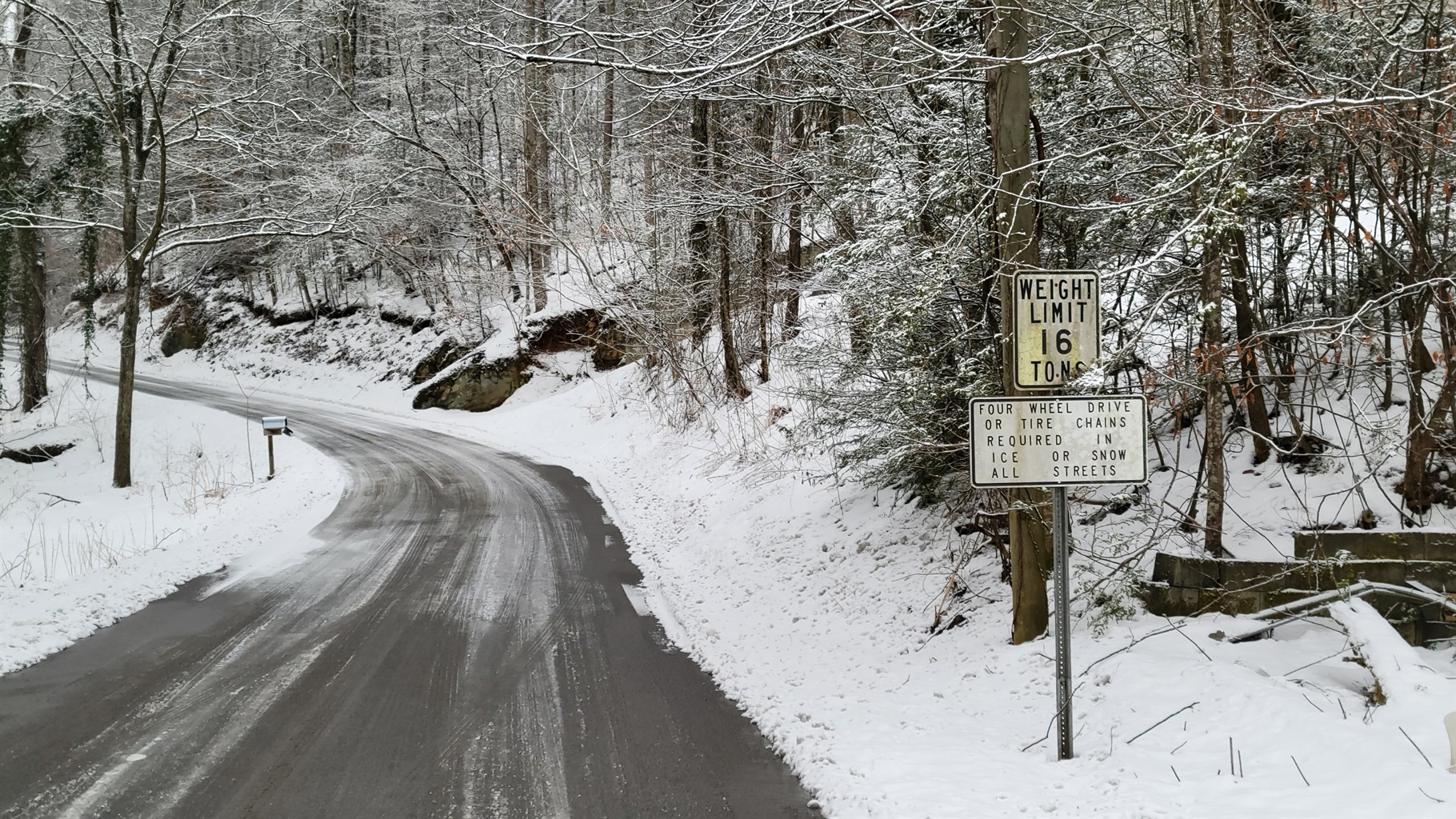 winter road covered in snow smokies with 4wd required sign