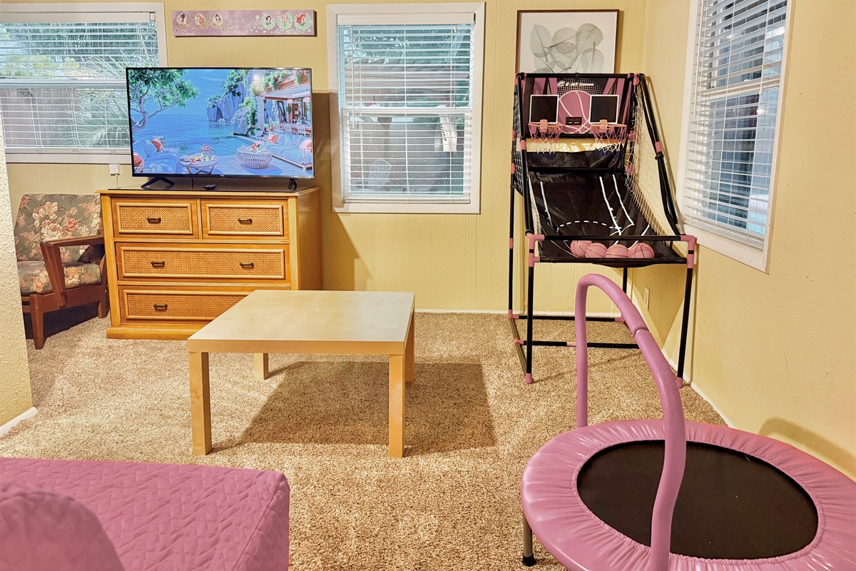This cheerful bonus room features a mini basketball arcade, kids' trampoline, and a flat-screen TV—perfect for rainy days or family bonding time!