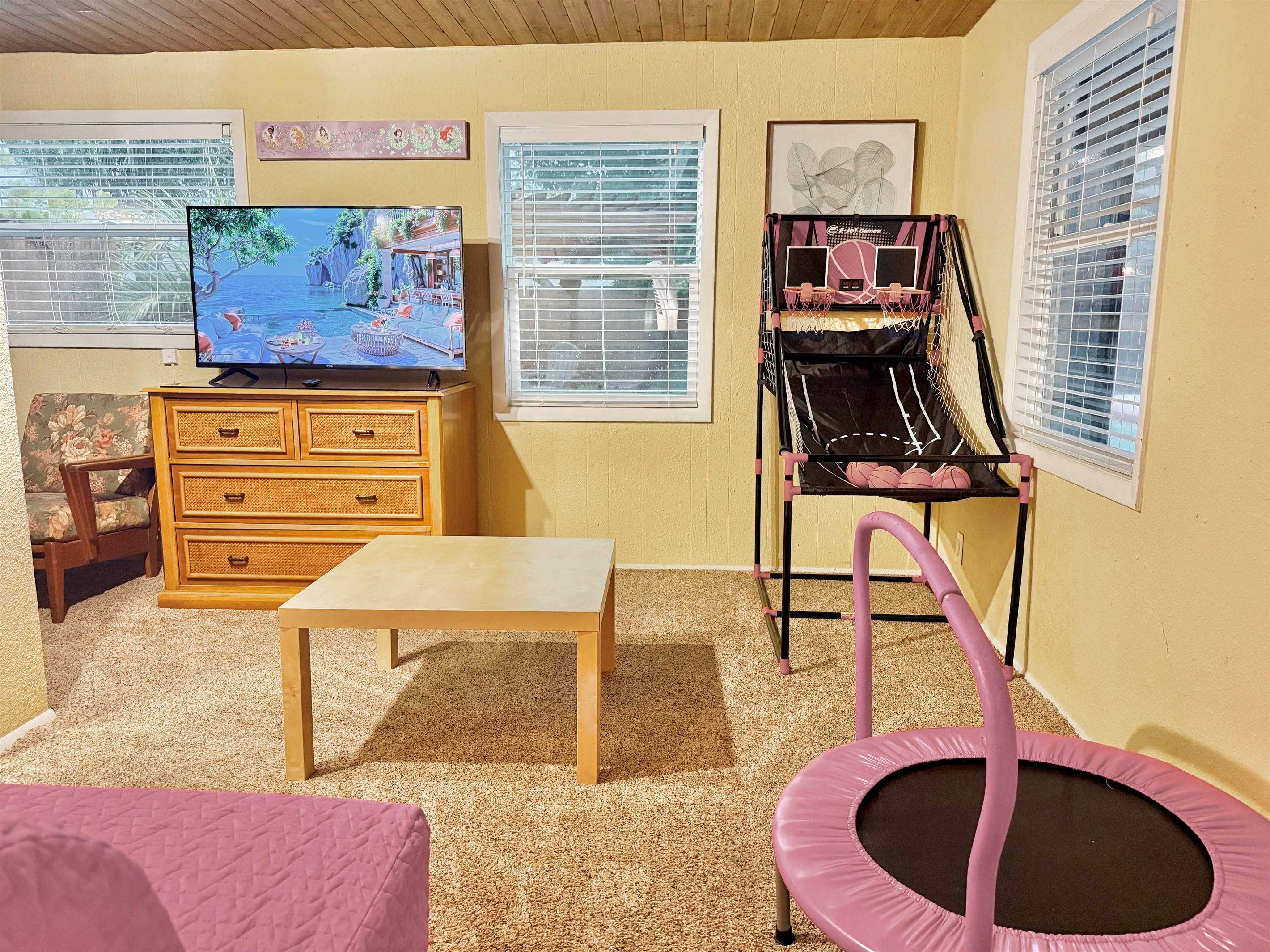 This cheerful bonus room features a mini basketball arcade, kids' trampoline, and a flat-screen TV—perfect for rainy days or family bonding time!