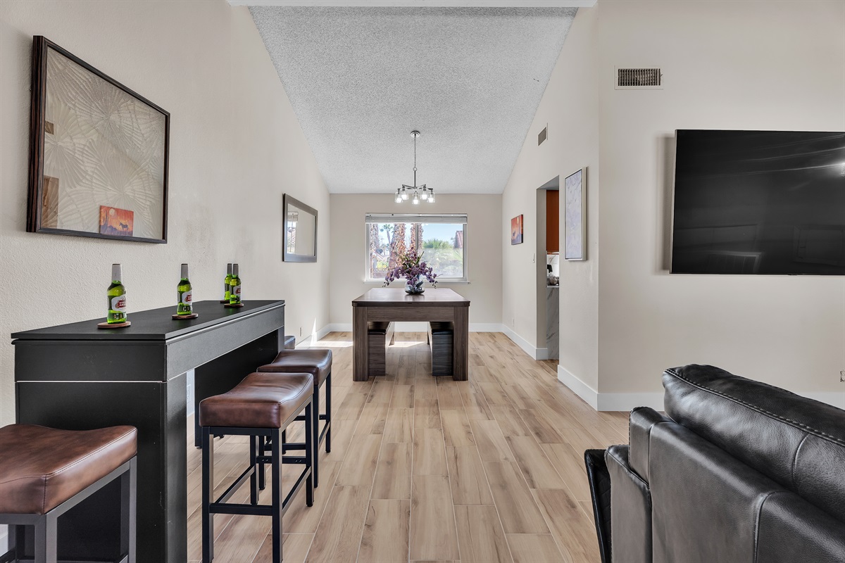 Living room 1 with 86 inch tv, simpsons arcade, bar table that converts to roulette and craps. Connects to dining room.