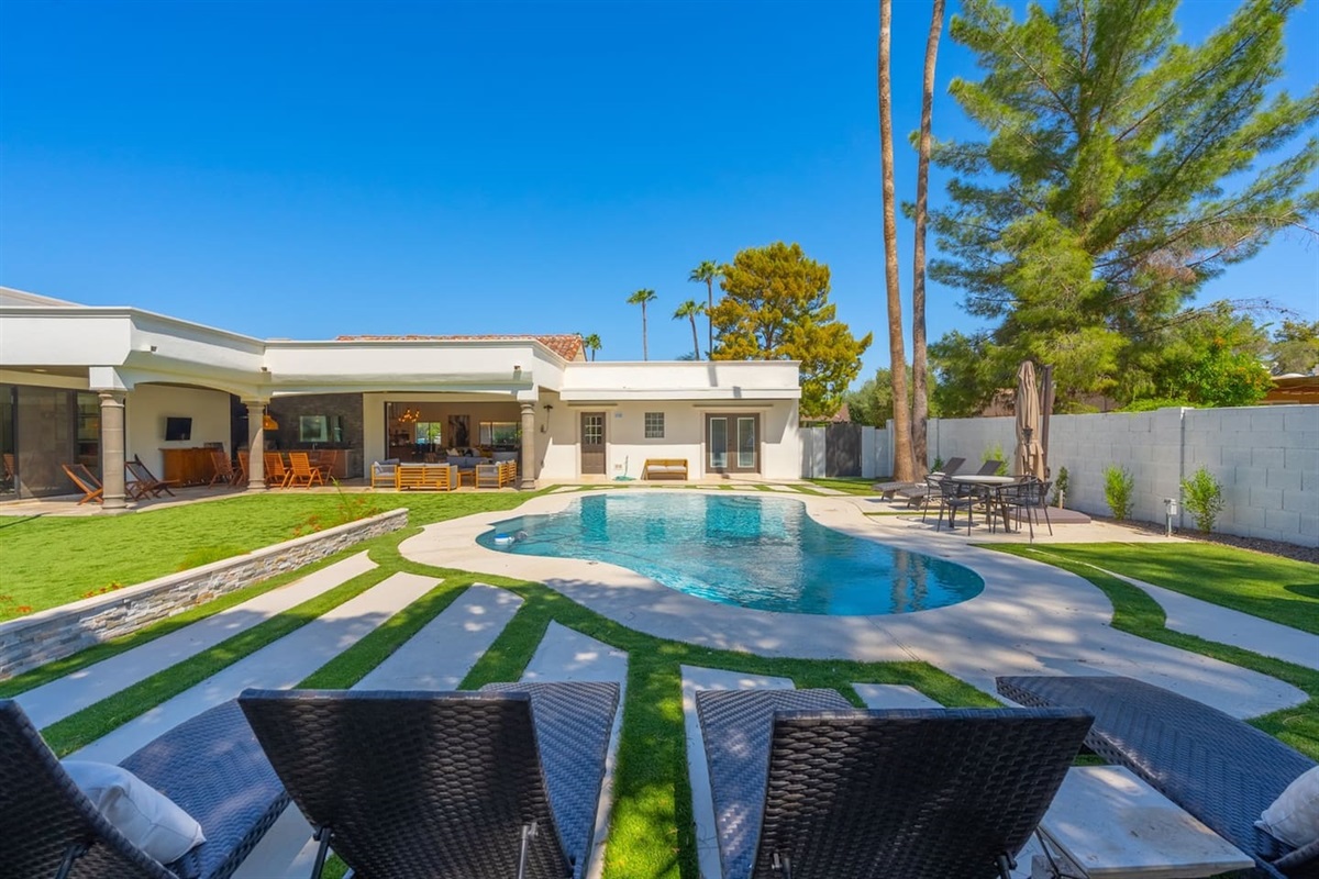 Bask in the sun by the pool, with lush plants and cozy outdoor furniture while staring the beautiful blue sky.