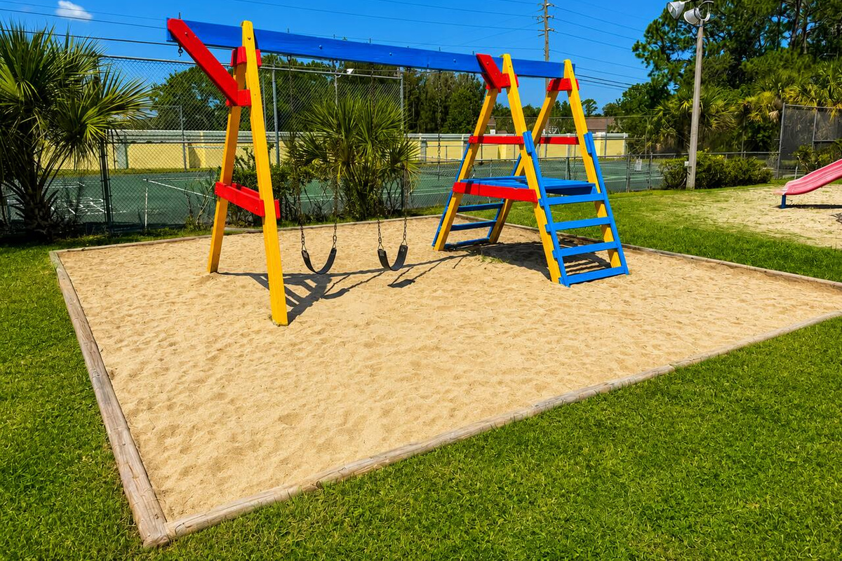 Sandy play area with swings and climbing equipment for family-friendly fun.
