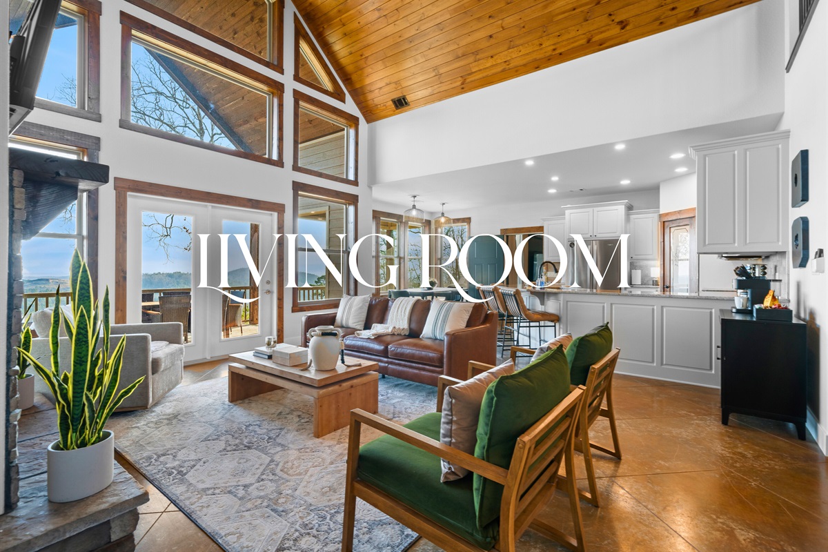 The open living room invites everyone to relax together, with cozy seating, warm wood ceilings, and natural light pouring in from every angle.